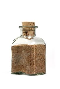 A glass bottle containing sand.